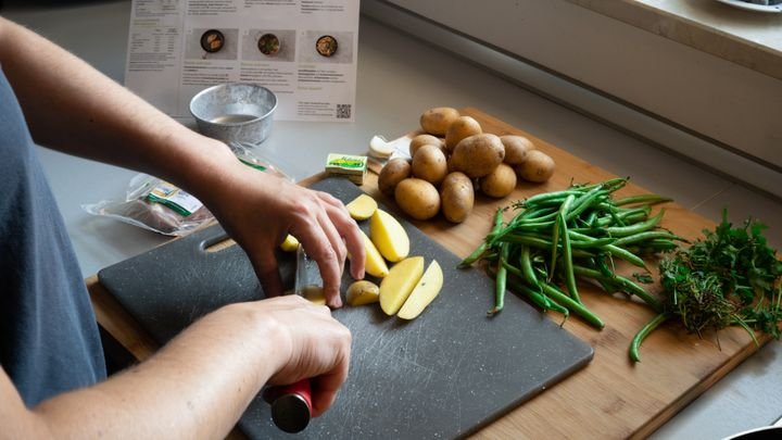 Für das Schweinelachssteak mit Bohnengemüse bereiten wir laut Rezeptkarte erst einmal das Mise en place vor und schneiden Kartoffeln.
